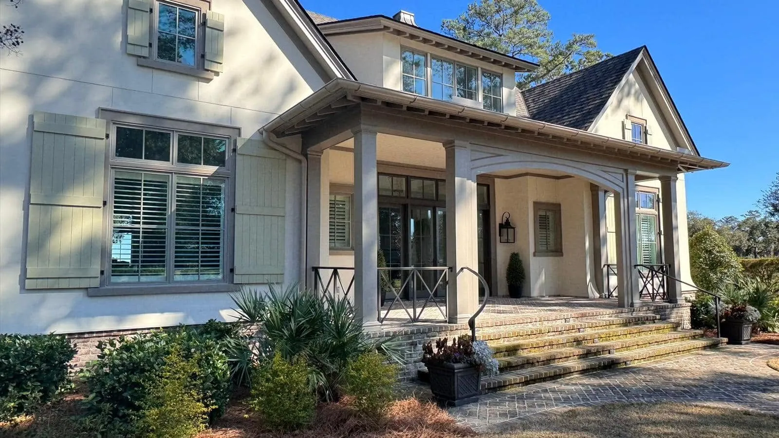 Two-story home with a deep front porch and new white gutters