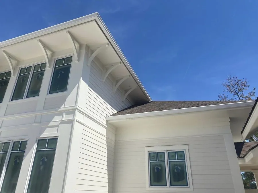 Home with a dark roof and new gutters along the eaves